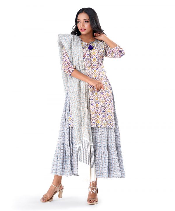 White all-over printed Salwar Kameez suit with a tiered-patterned long gown and printed Kameez as a layer. Designed with a tie-cord neckline and jeweled tassels on the slits. Complemented with printed half-silk dupatta and Pajamas.