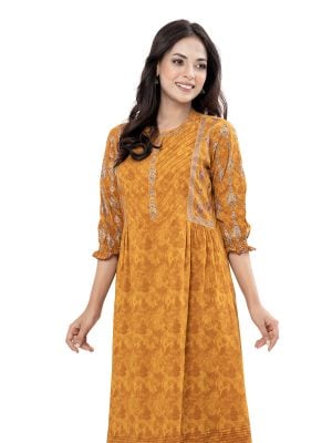 Mustard Yellow all-over printed A-line Tunic in Viscose fabric. Features a band neck with hook closure at the front and cinched bishop sleeves. Embellished with embroidery and pin tucks at the top front. Gathers from the waistline. Swing stitches and patch attachment at the hemline.