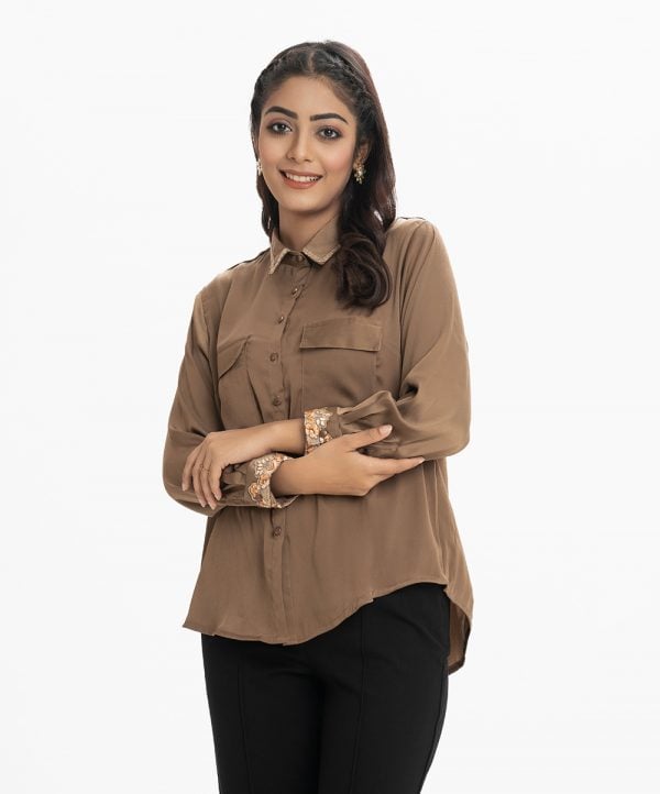 Lady's long-sleeved with embroidery details at the cuff shirt in joom fabric. Classic collar with lace work. two pockets and button fastening at the front.