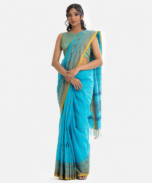 Printed saree in cotton fabric. Embellished with karchupi and fringe trim at the border of anchal.