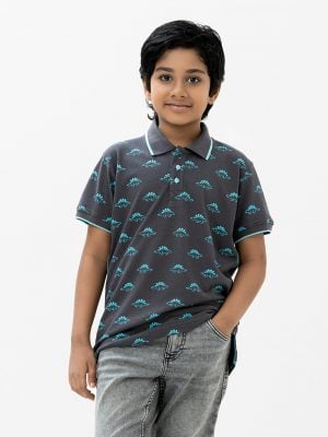 Kids boy Polo Shirt in cotton pique fabric. Classic collar, short sleeves and all over dinosaur printed.