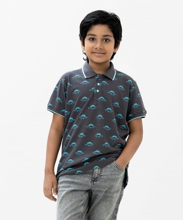 Kids boy Polo Shirt in cotton pique fabric. Classic collar, short sleeves and all over dinosaur printed.