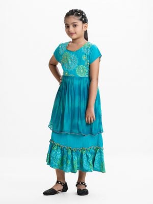 Kid girls printed frock in viscose fabric with chiffon fabric patch attached at waistline. Cap sleeves, embroidery at front and tie-cord at back.