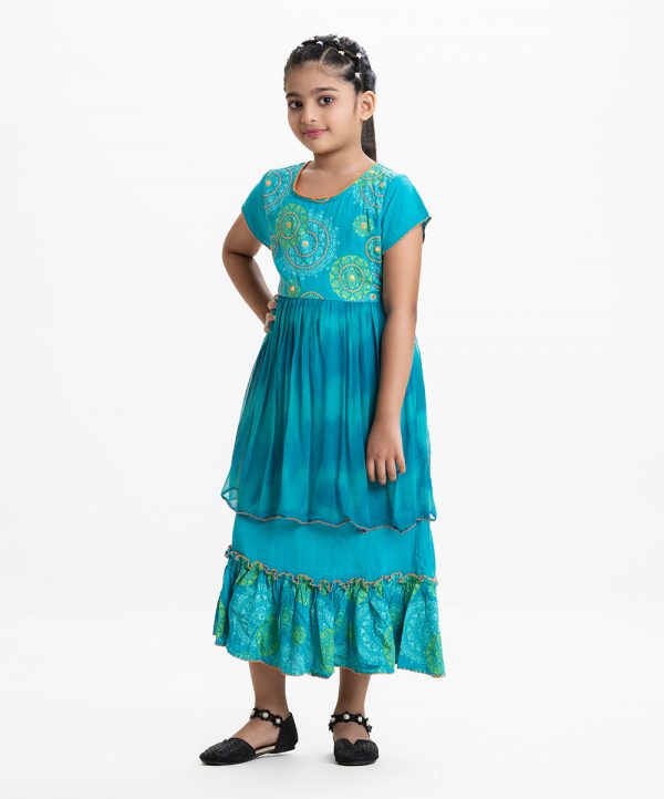 Kid girls printed frock in viscose fabric with chiffon fabric patch attached at waistline. Cap sleeves, embroidery at front and tie-cord at back.