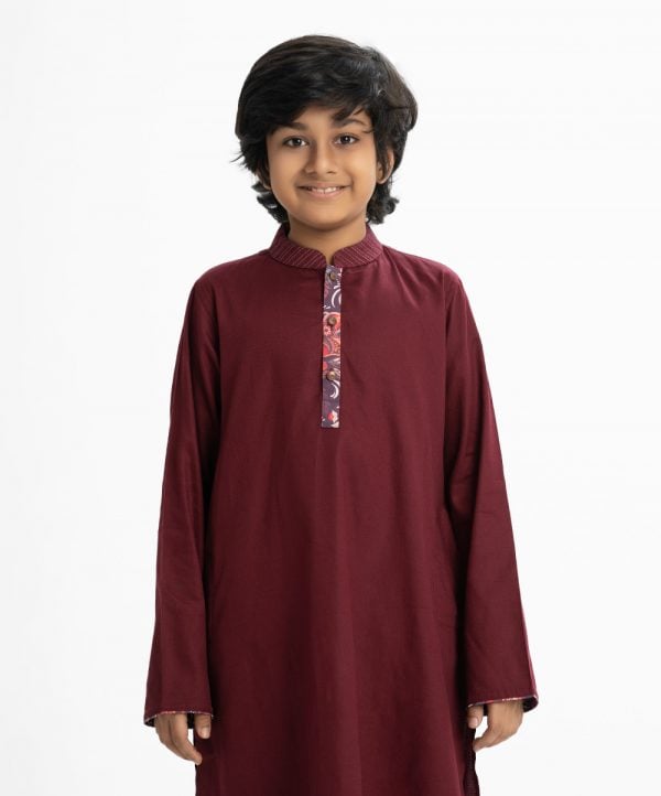 Kid boys panjabi in cotton fabric. Mandarin collar and inseam pockets. Patch at placket and line stitching at collar.