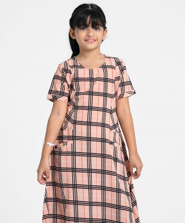 Kids girl A-line frock in georgette fabric. Round neck, short-sleeved. Two jetted pockets at the front and a belt.