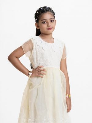 Kid girls frock in organza fabric with crepe full body inner. Scalloped peter pan collar, Cap-sleeved. Embroidery cutwork at front and bottom.