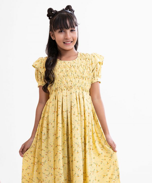 Kid girls frock in floral printed georgette fabric with half-body viscose inner. Puff sleeved and pin tuck at front with tie-cord belt.