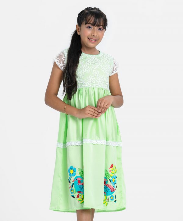 Kid girls frock in crepe fabric. Round neck, short-sleeved. Embroidery and gathered at the front. Print and frill trim at the hemline. A belt.