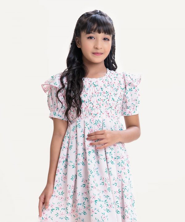 Kid girls frock in printed georgette fabric. Round neck, puff sleeves. Pin-tuck at front.