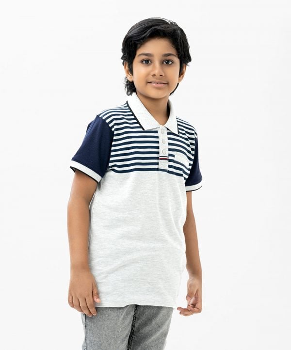 Kid boy polo shirt in cotton pique fabric. Classic collar with button placket and short sleeves.