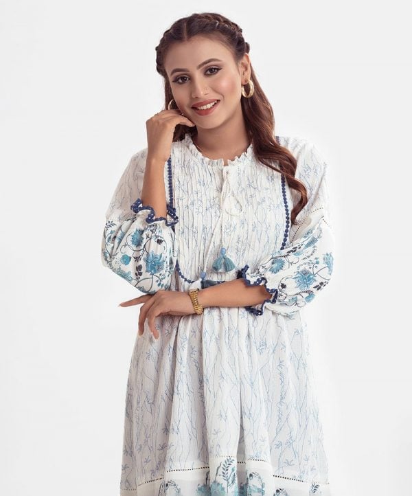 Printed frock-style tunic in georgette fabric. Ruffle neck, attached patch at the puff-sleeves and hemline.