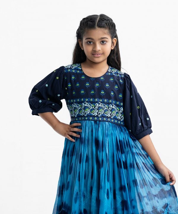 kid girls printed tent-style layered tunic in viscose and georgette fabric. puff-sleeves, round neck. Gathered at the waistline with a tassel tie.