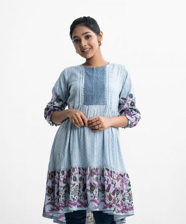 Teen girls printed A-line tunic in crepe fabric. Round neck, long-sleeved patchwork at the front. Gathered at the waistline and frills at the hemline.