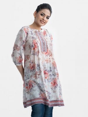 Women's floral printed A-line tunic in blended cotton fabric. Stand collar, three-quarter sleeves. Patchwork at front and hemline.