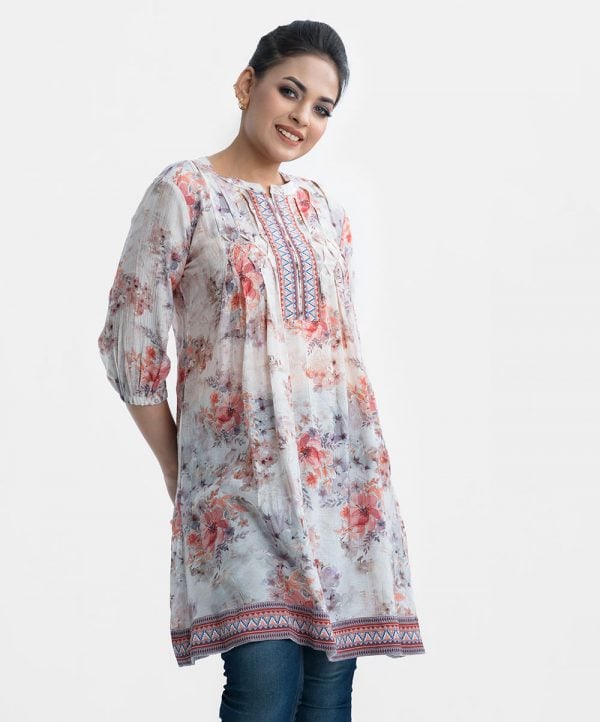 Women's floral printed A-line tunic in blended cotton fabric. Stand collar, three-quarter sleeves. Patchwork at front and hemline.