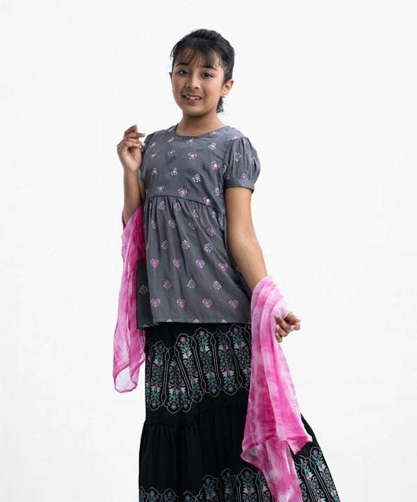 Kid girls ghagra choli in crepe fabric. Round neck, puff-sleeved and karchupi at the front. Competed with A-line skirt and tie dye dupatta.