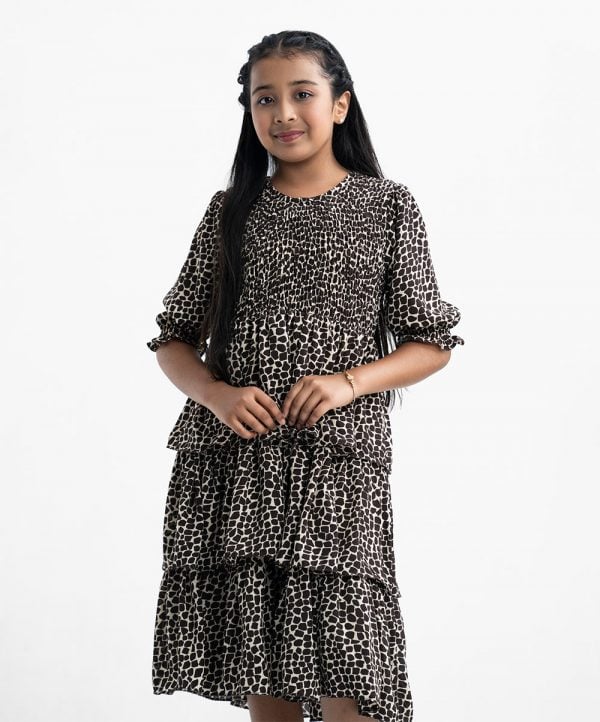 Kid girls tiered style frock in georgette fabric. Round neck, puff-sleeved and smokey at the front.