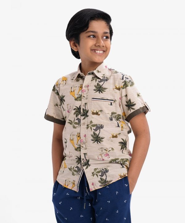 Kid boy's printed short-sleeved casual shirt in cotton fabric. Classic collar, button fastening at the front with a chest poket.